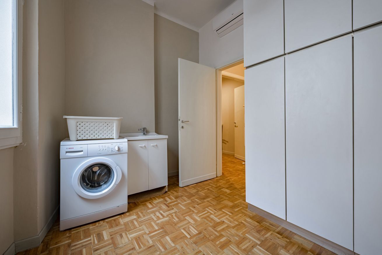 Una sala amb bugaderia, que inclou una rentadora, un escuraprius i un armari.
