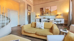 Een woonkamer met een bank, een eettafel en een keukenhoek.
