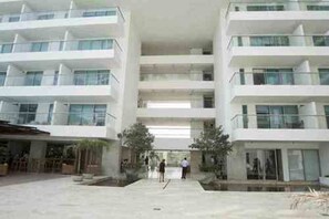 Un hotel de varios pisos con un atrio central, zona de estar al aire libre y un paseo techado.