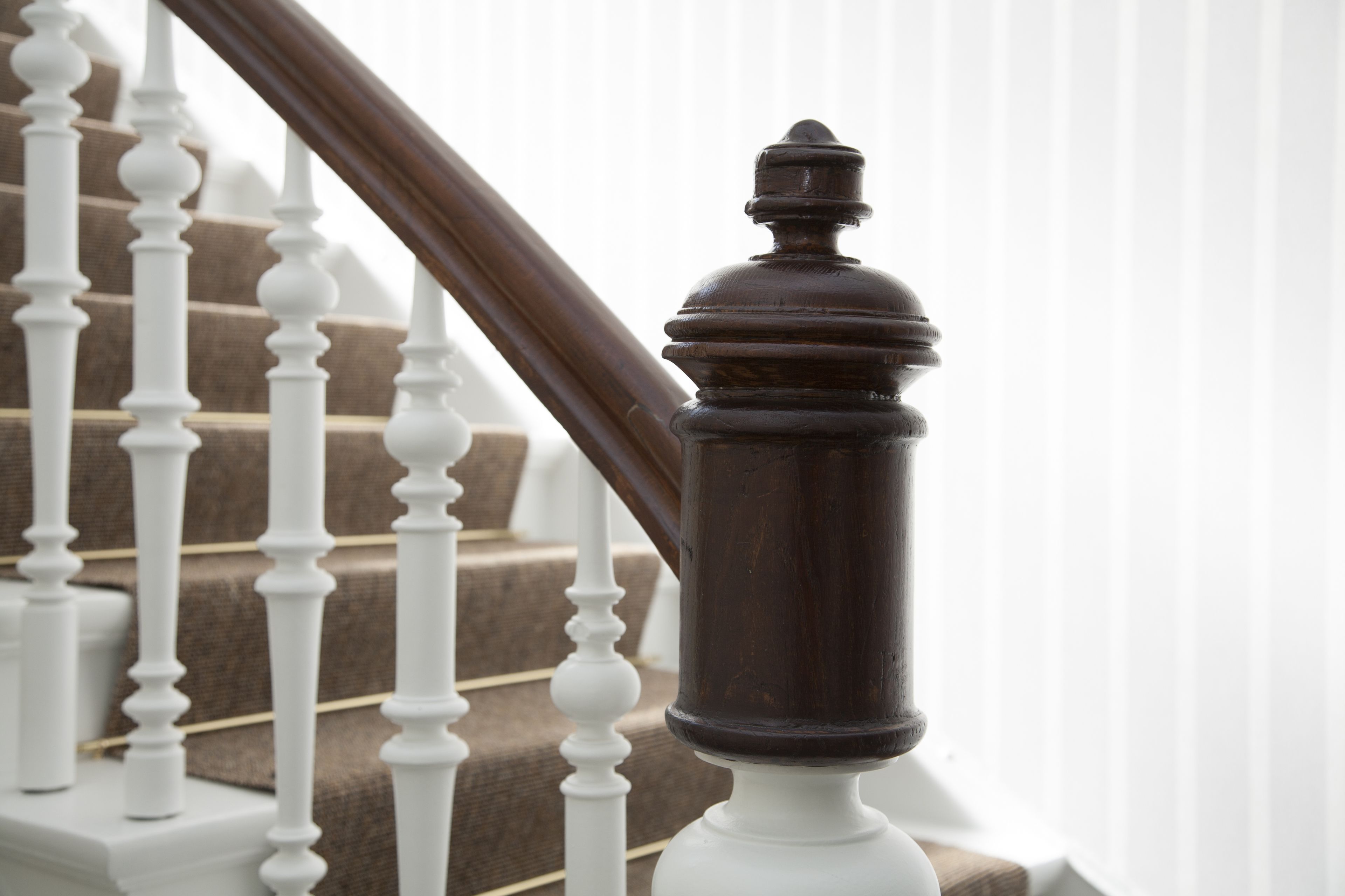 A staircase with white balusters and dark wooden handrails.