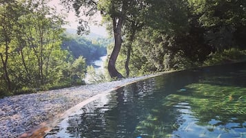 Una piscina techada, una piscina al aire libre de temporada, sombrillas