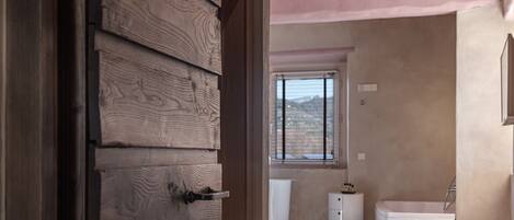 Una camera da letto con un'armadio in legno, una finestra con vista, un letto bianco e un comodino bianco.