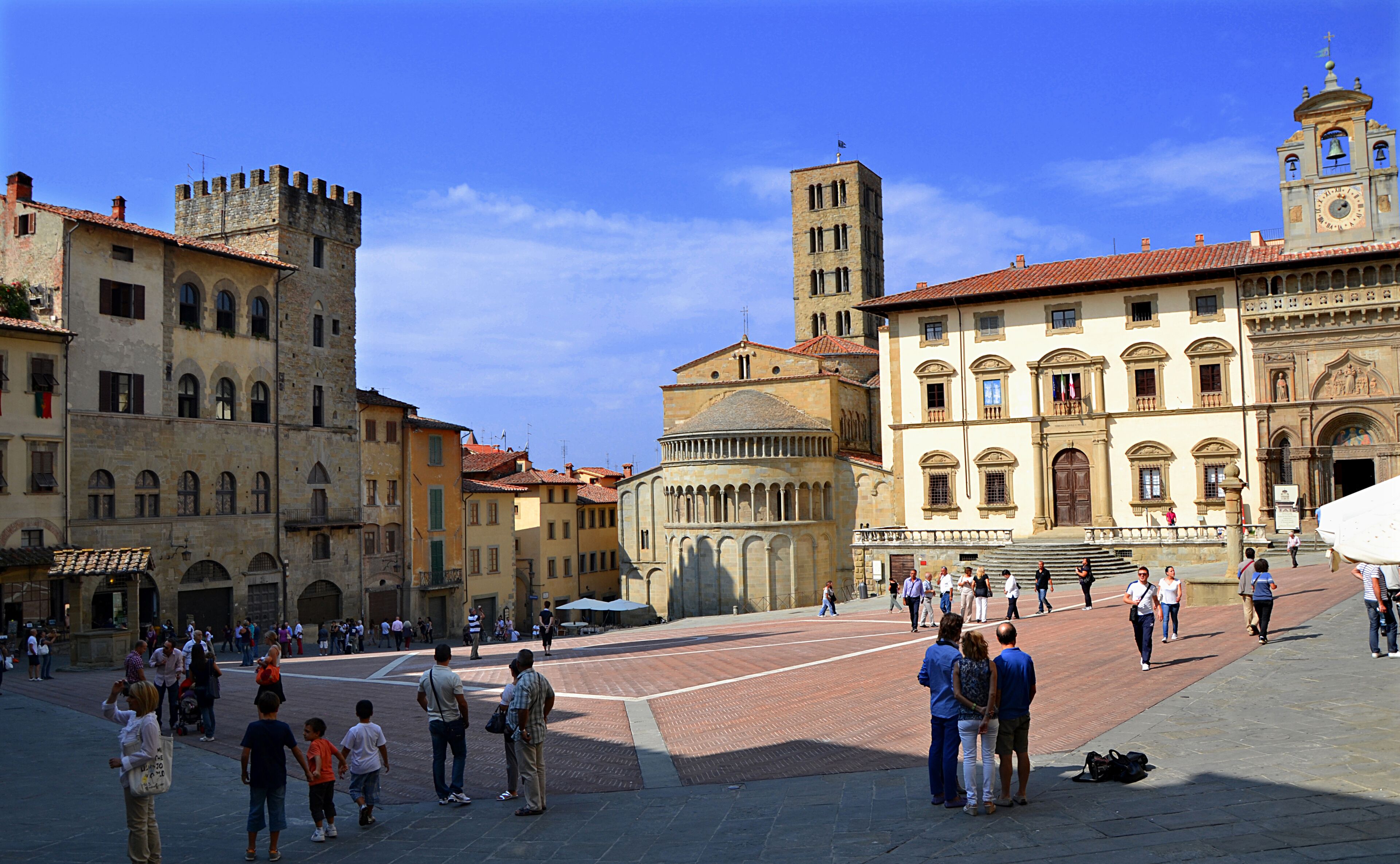 A historic square with a prominent church, a bell tower, and a castle-like building.