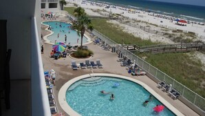 A hotel with a pool area, beach access, and a view of the ocean. - Lighthouse 801 Corner Unit Beachfront w HUGE wrap balcony! Book for Aug., Fall! (Gulf Shores)