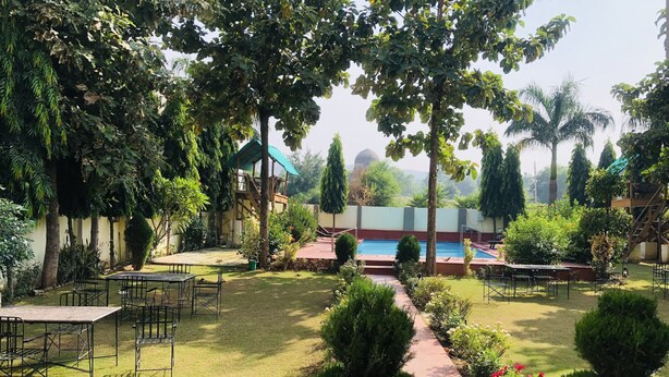 A garden with a swimming pool, outdoor seating, and a covered area. - Ranthambore City Heart (Sawai Madhopur)
