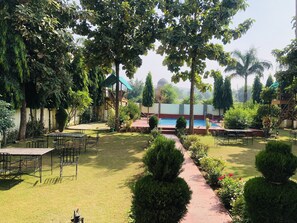 A garden with a swimming pool, outdoor seating, and a covered area. - Ranthambore City Heart (Sawai Madhopur)