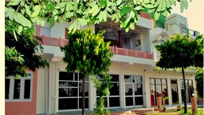 A two-story building with large windows and a red brick pathway leading to the entrance. - Ranthambore City Heart (Sawai Madhopur)