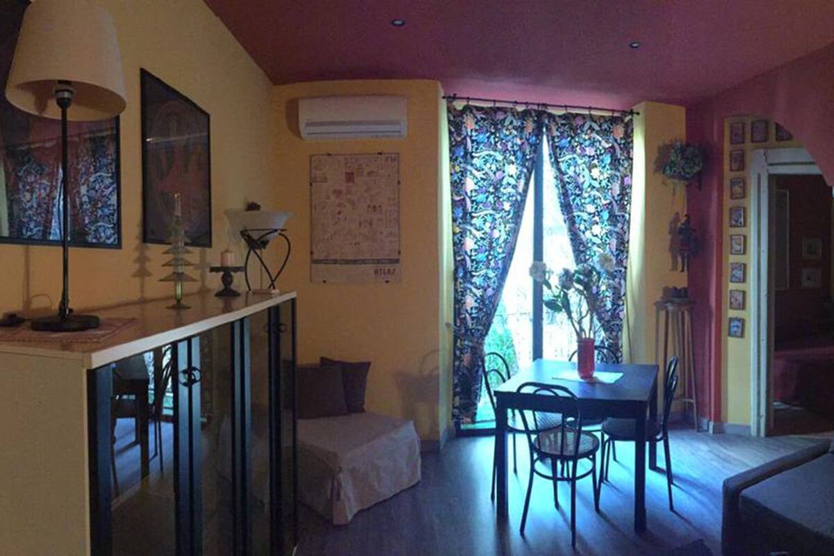 Un espacio habitable compacto con comedor, sofá y kitchenette.