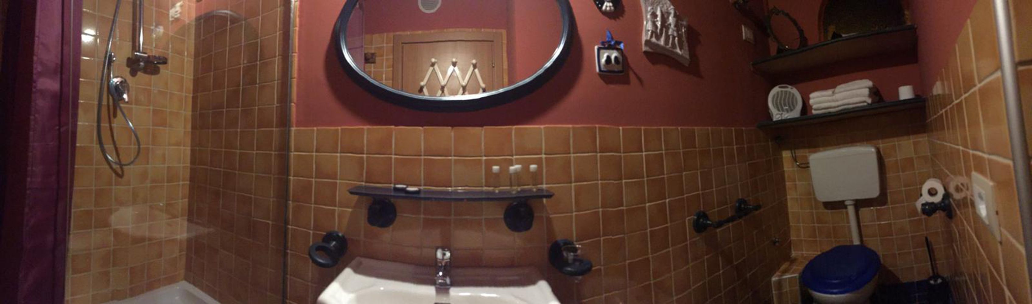 Un baño con lavamanos, espejo e inodoro.