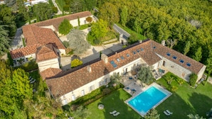 An aerial view of a large estate with multiple buildings, a swimming pool, and well-maintained gardens. - Domaine de Labarthe (Espere)