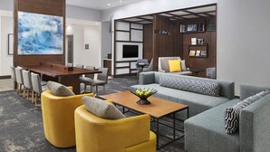 A modern living room with a dining area, a flat-screen TV, and a bookshelf.
