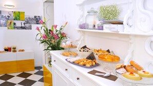 Une table de buffet garnie de diverses pâtisseries et un vase rempli de fleurs.