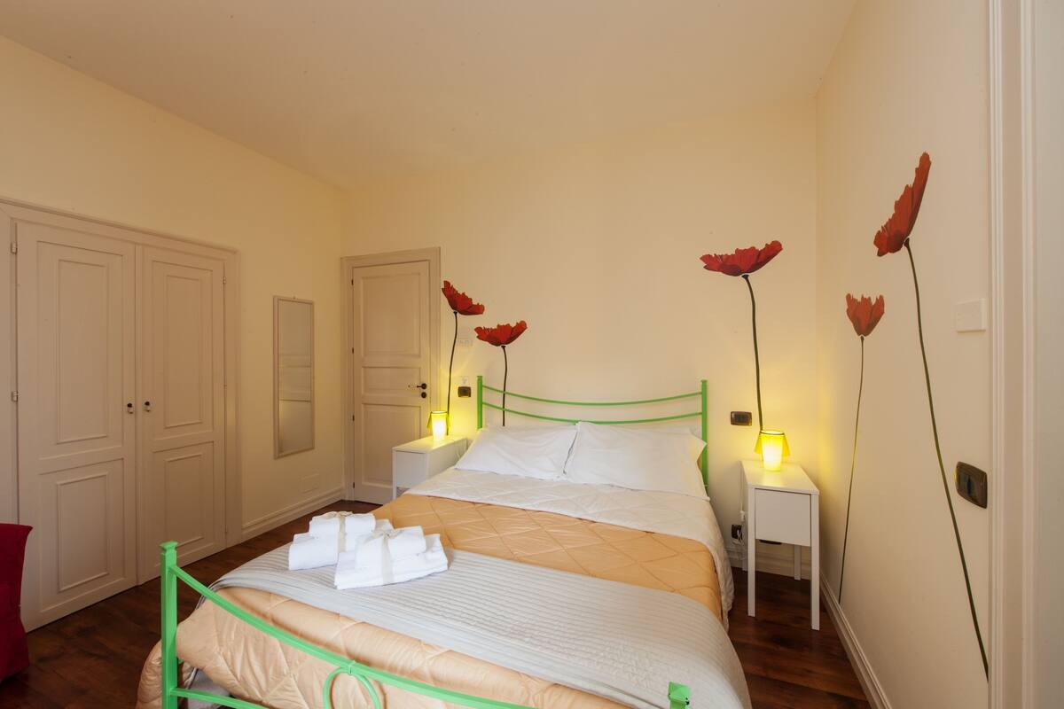Un dormitorio ordenado con cama, mesitas de noche y un armario.