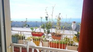Un balcon agrémenté de plantes en pot et offrant une vue sur la mer.
