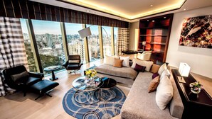 A modern living room with a large window, a sofa, a coffee table, and a bookshelf. - Apartments by Fairmont Baku Flame Towers (Baku)