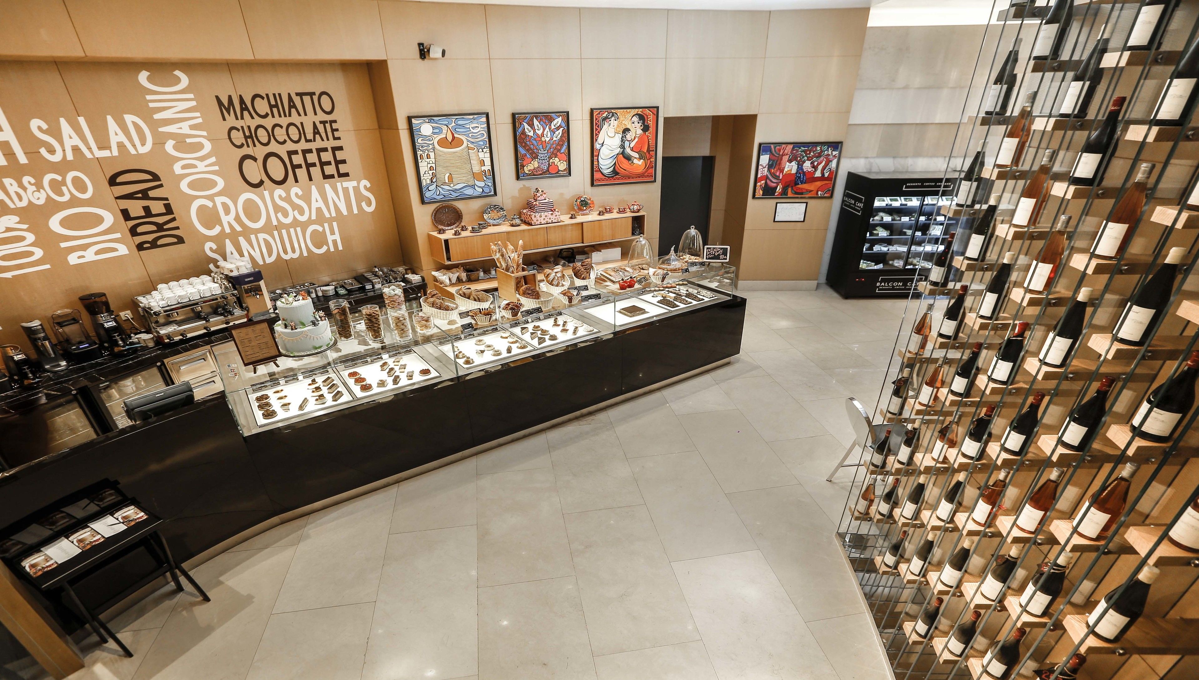A bakery counter with various baked goods and a wine display.