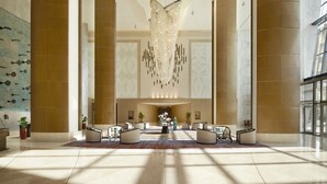 A spacious lobby with high ceilings, a large chandelier, and a central seating area. - Apartments by Fairmont Baku Flame Towers (Baku)