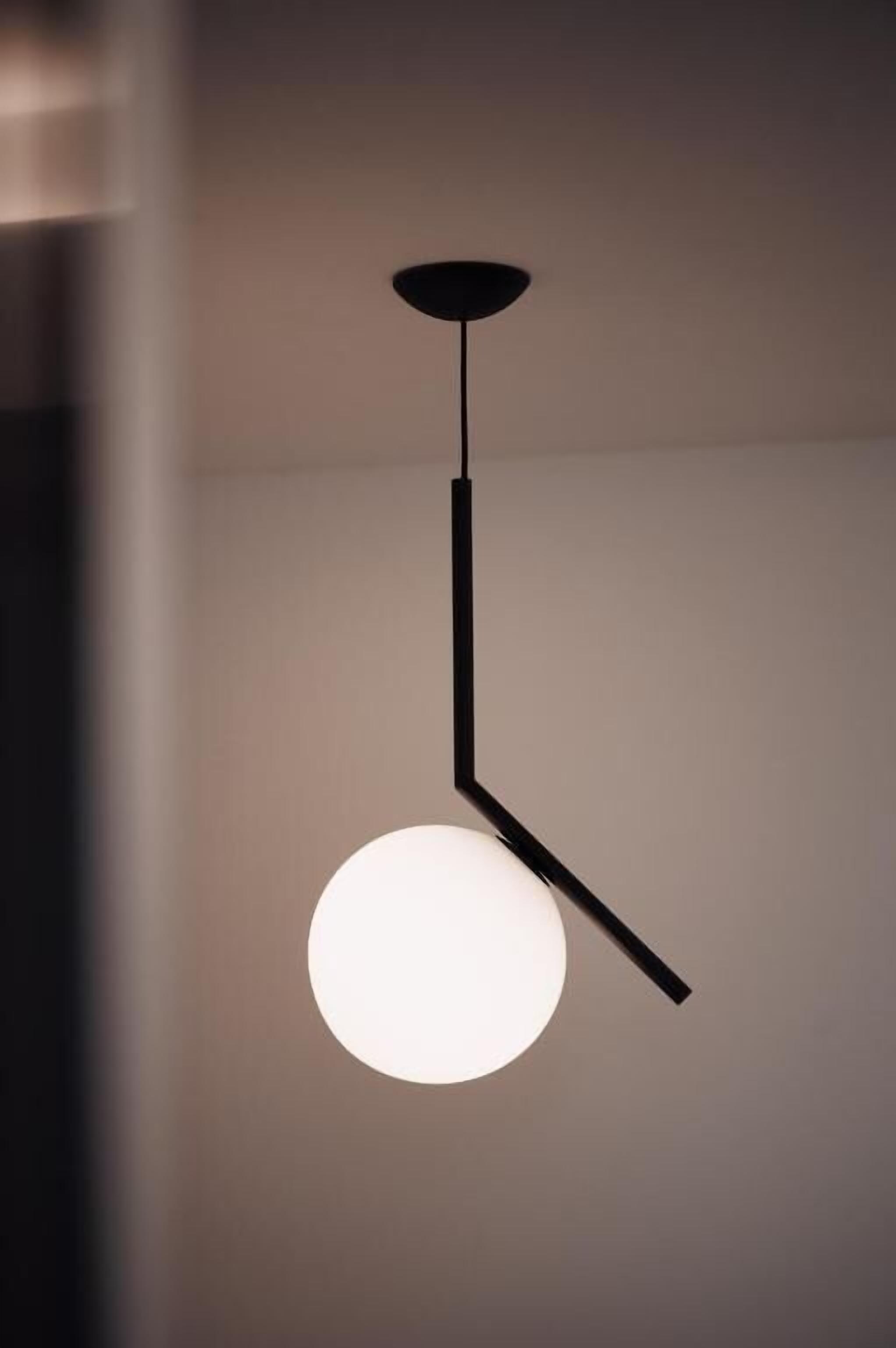 Una lámpara colgante moderna con bombilla esférica y diseño minimalista.