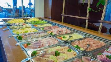 A buffet with various food options including meats, cheeses, and vegetables.