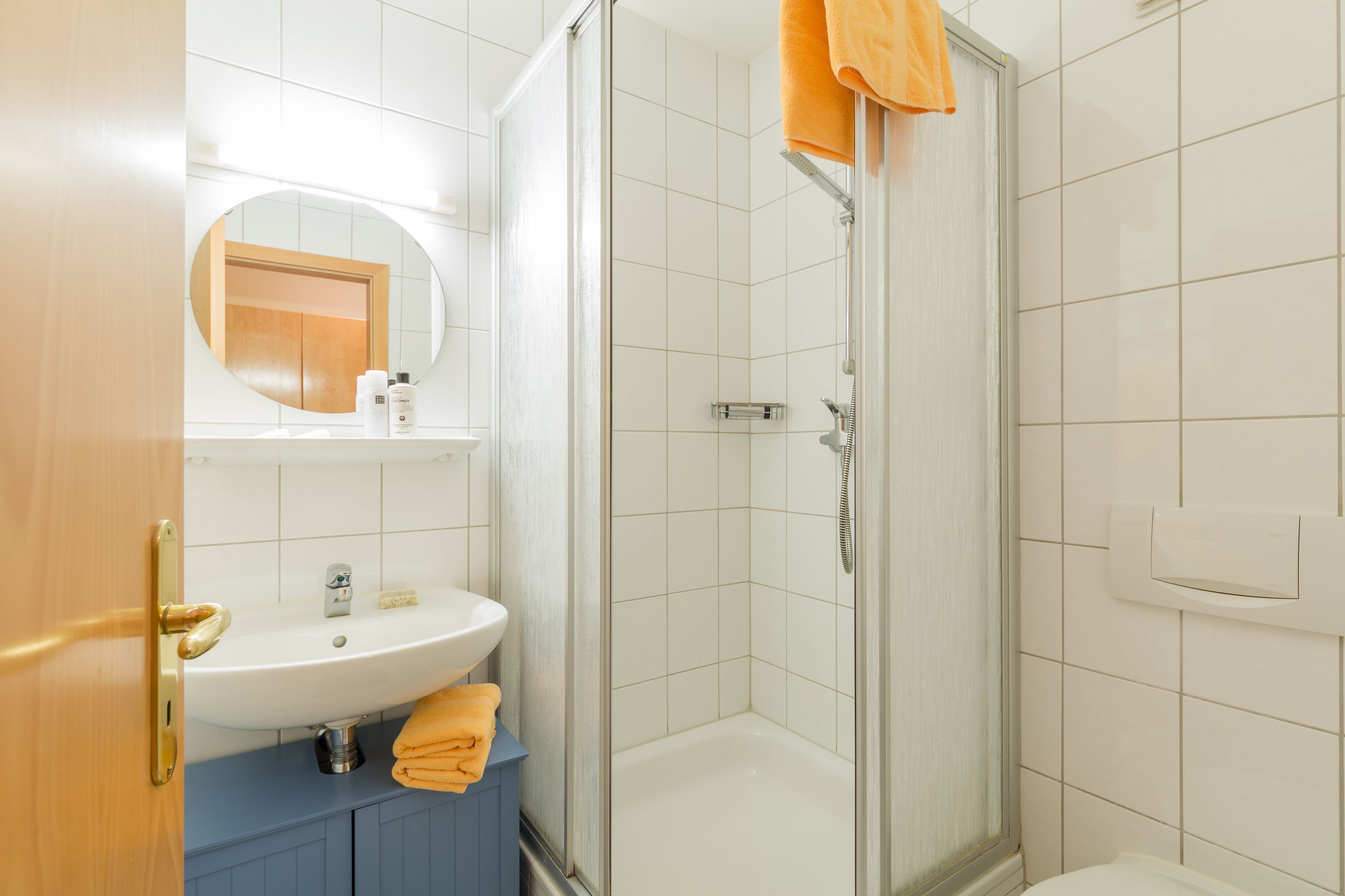 A bathroom with a sink, mirror, and shower.