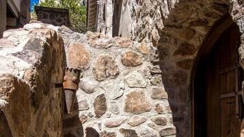 Un estrecho sendero de piedra que conduce a una puerta de madera en un edificio rústico.