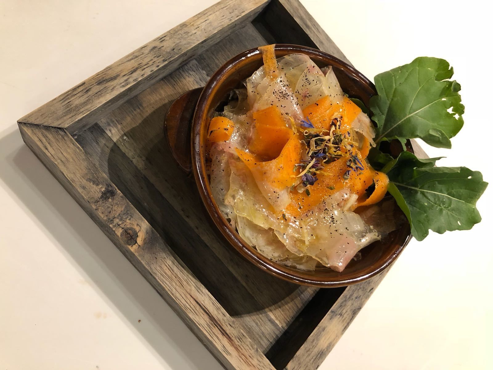 A bowl of food on a wooden tray.