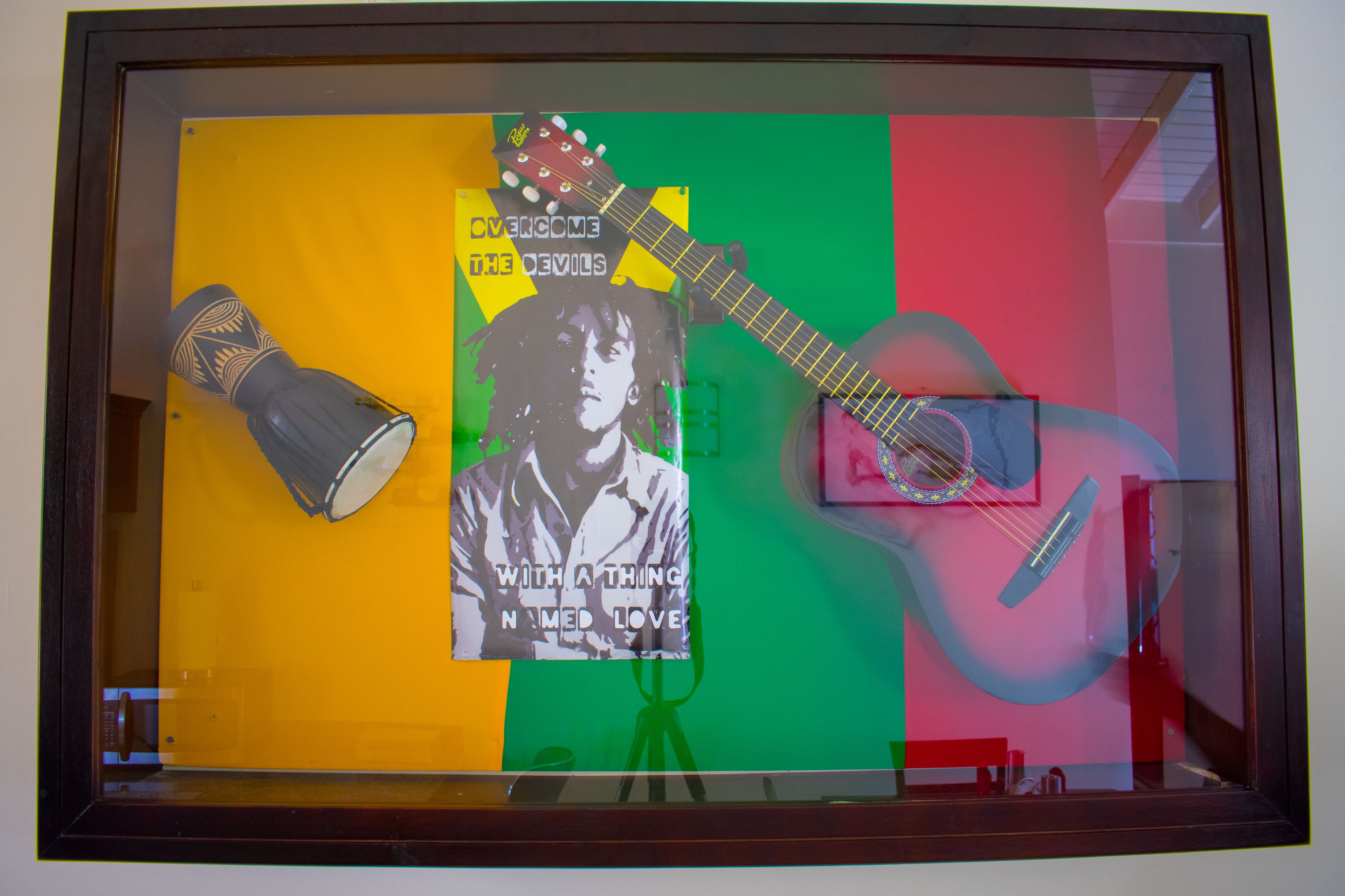 A framed artwork with a guitar, a microphone, and a poster.