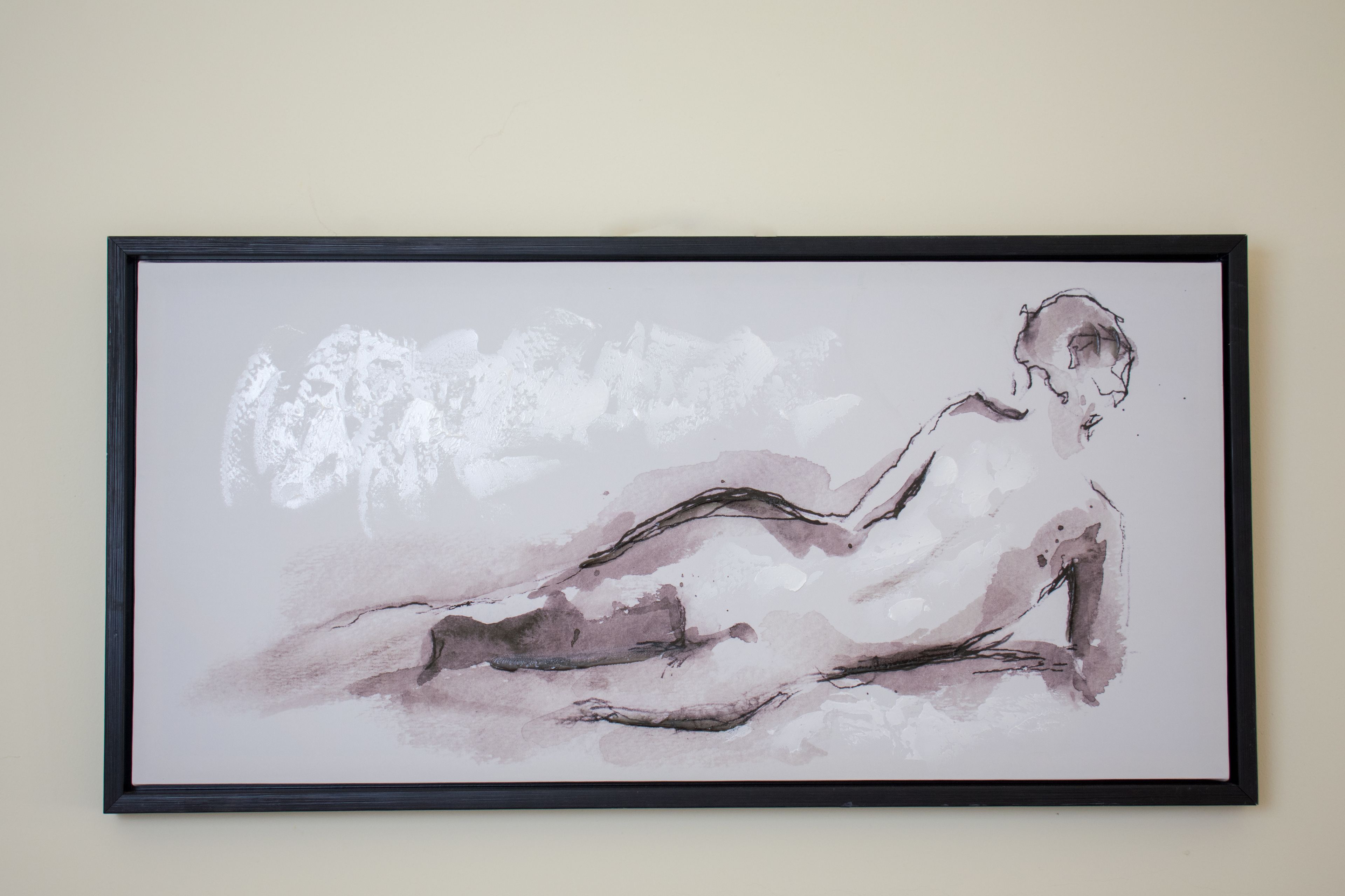 Una obra de arte enmarcadas de una figura sentada de estilo minimalista.