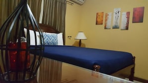 Een hotelkamer met een bed, een lamp en kunst aan de muur.