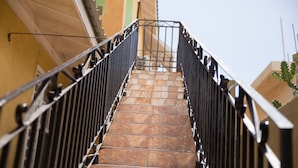 A staircase with metal railings leading to a higher floor. - Apartment in Hellshire near Beach (Hellshire)