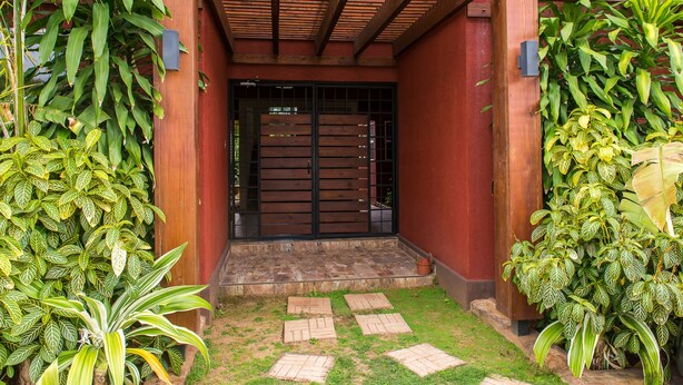 A wooden entrance with a black gate, surrounded by lush green plants. - Kinsgton Modern Duplex Apartment with Pool (Kingston)