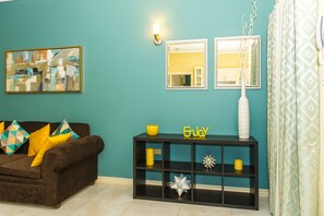 Apartamento superluxo, vista para a piscina | Área de estar | TV de tela plana 50 polegadas com canais a cabo, TV, DVD player
