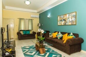 Luxury Apartment, Pool View | Living room | 50-inch flat-screen TV with cable channels, TV, DVD player - The US Embassy Luxury Apartment (Kingston)
