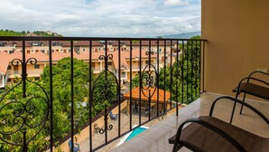 A balcony with a view of a residential area, including houses and greenery.