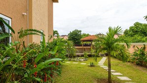 A well-maintained garden with a paved pathway leading to a wooden deck.