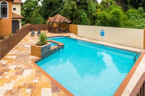 A swimming pool with a tiled deck, a small garden area, and a gazebo. - Kingston Luxury Family Retreat (Kingston)