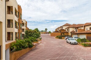 A residential street with apartment buildings, a paved driveway, and parked cars. - Kingston Luxury Family Retreat (Kingston)