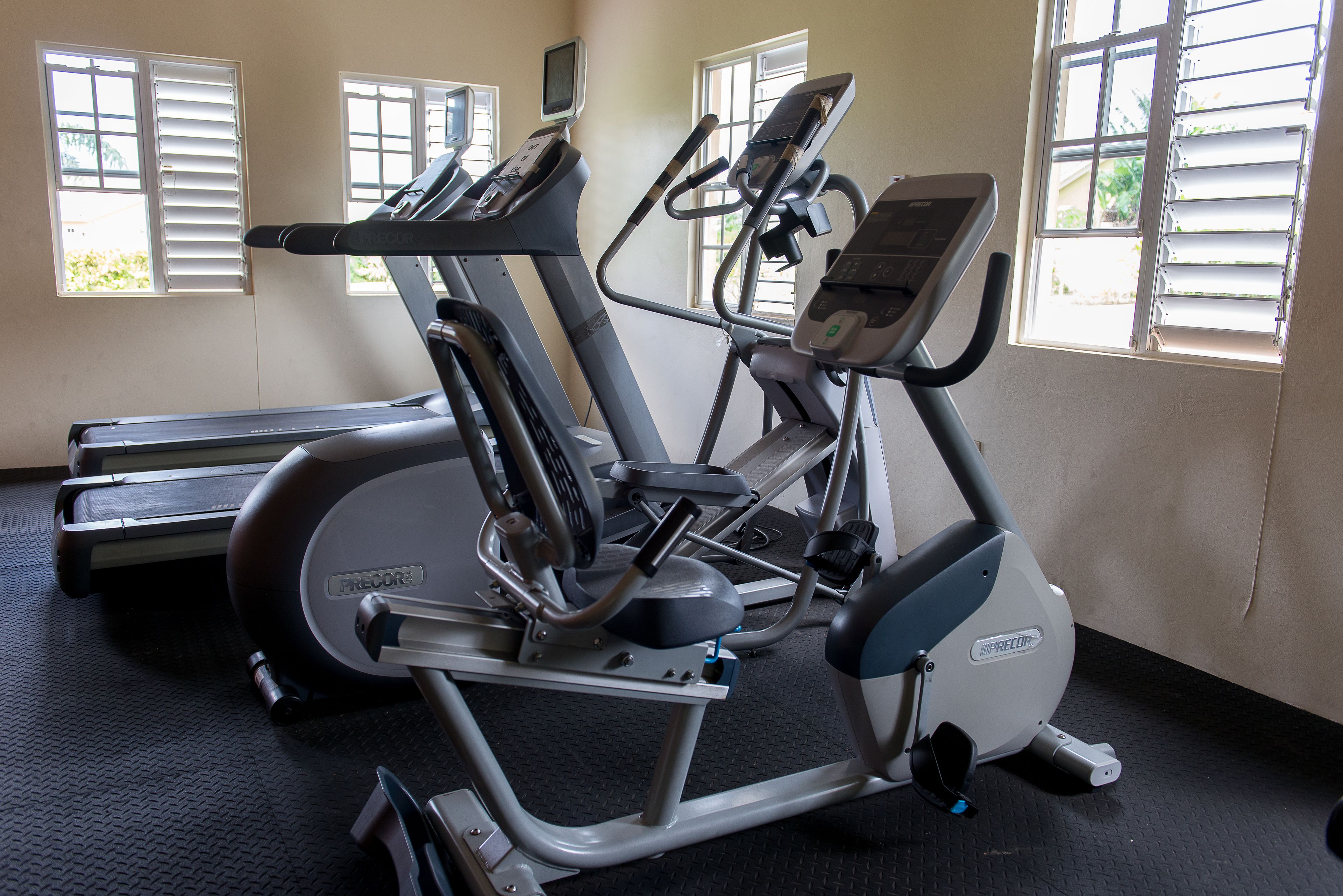 Une salle de sport équipée de tapis de course, d’un vélo elliptique et d’un vélo d’appartement.