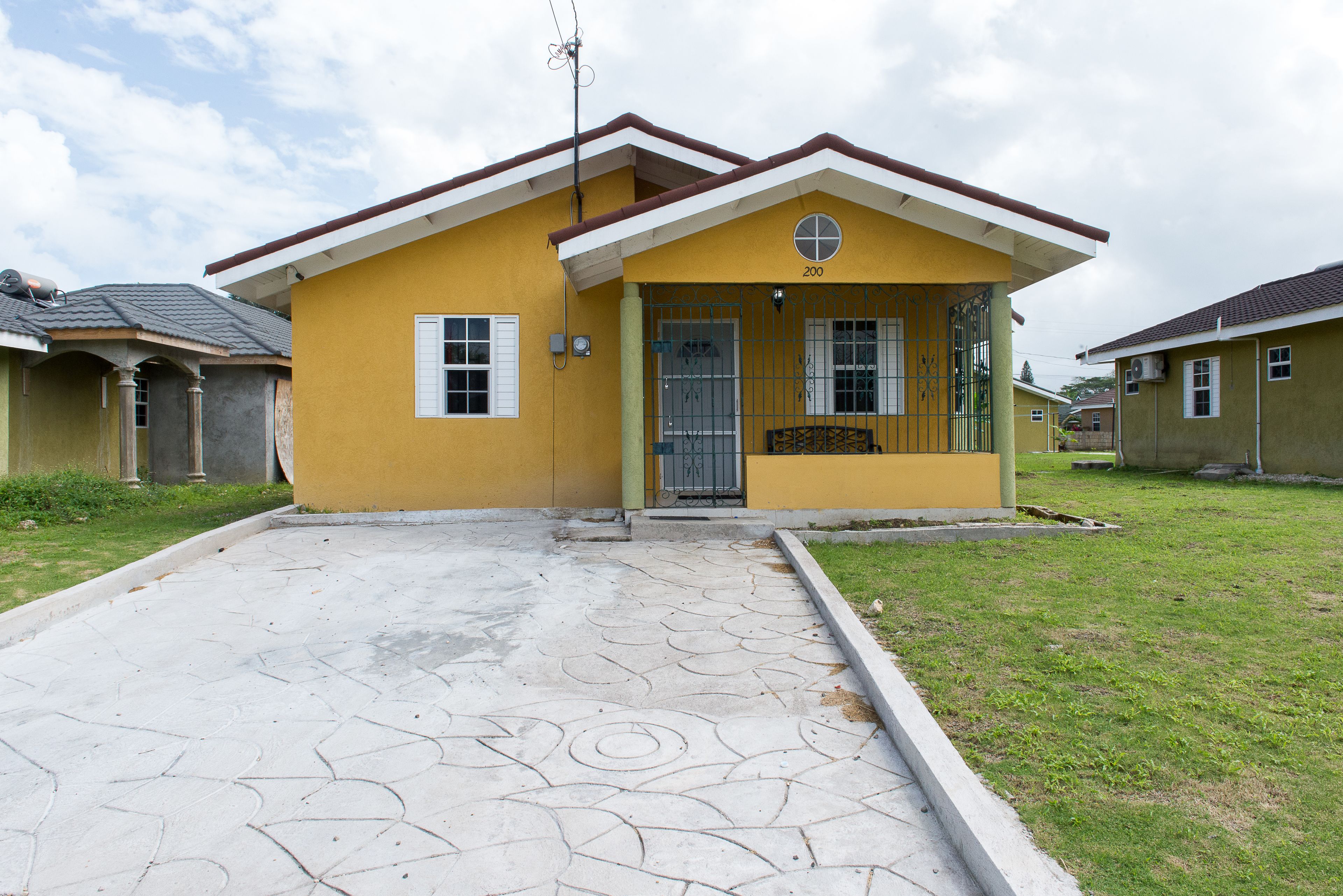 A yellow house with a tiled entrance and a small porch.