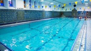A large indoor swimming pool with tiled walls and a tiled pool deck.