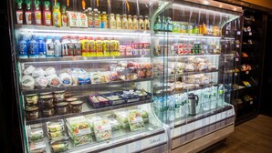 A refrigerated display case in a store with various food items and beverages.