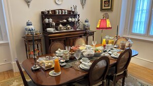 Comedor con mesa de madera dispuesta para el desayuno, rodeado de sillas.