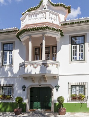 A traditional building with a green door, white walls, and a balcony with ornate railings. - Villa Estefânia (Sintra)