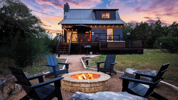 A rustic cabin with a fire pit and outdoor seating.