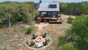 A house with a deck, outdoor seating, and a fire pit.