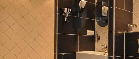 A modern bathroom with a white bathtub, a sink, and a toilet.