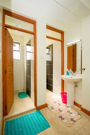 Habitación doble Deluxe | Baño | Regadera, regadera tipo lluvia, amenidades de baño gratuitas, toallas 