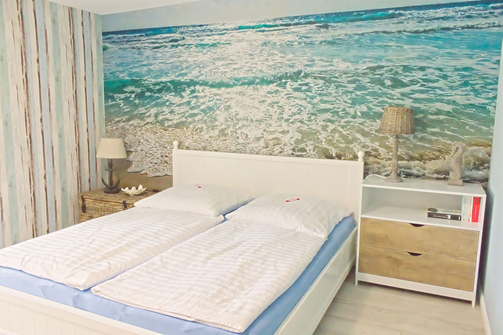 A bedroom with a bed, a nightstand, a lamp, and a bookshelf.