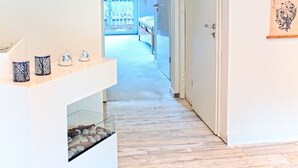 A modern hallway with a wooden floor, a white wall, and a door leading to a balcony. - Vacation in peace & nature - apartment on the Bodden with fenced plot. & water access (Wiek)