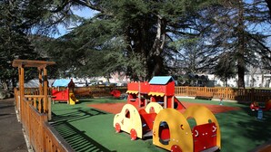 Um parquinho com estruturas de recreação, incluindo um trem e um escorregador.
